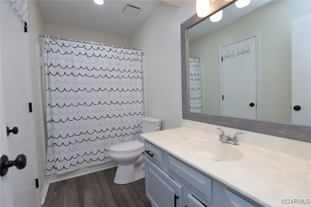 full bathroom with vanity, a shower with curtain, wood finished floors, visible vents, and toilet