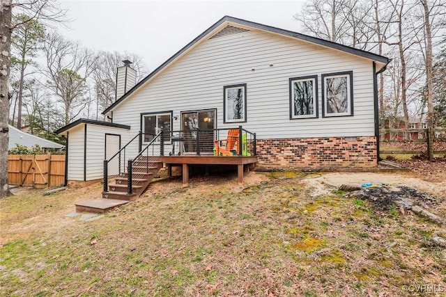 back of property with a wooden deck, a chimney, and fence