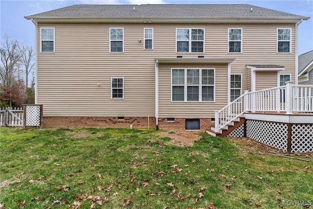 back of property with a wooden deck, a lawn, fence, and crawl space