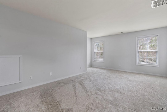 spare room featuring visible vents, carpet, and baseboards