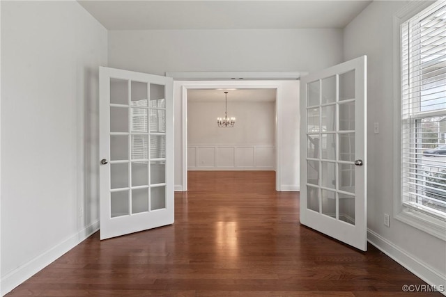 interior space featuring a notable chandelier, french doors, baseboards, and dark wood-style flooring