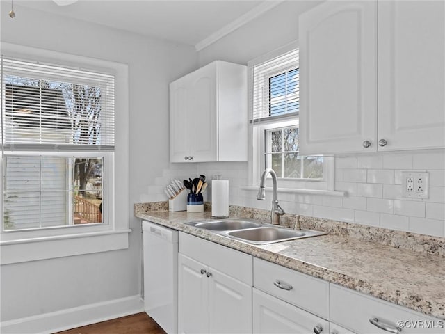 kitchen with a sink, tasteful backsplash, white dishwasher, and white cabinetry