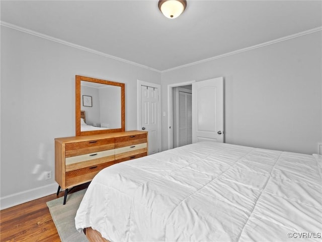 bedroom featuring crown molding, baseboards, and wood finished floors