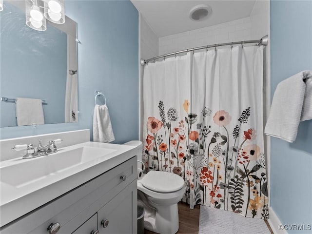 full bathroom with a shower with shower curtain, toilet, vanity, and wood finished floors