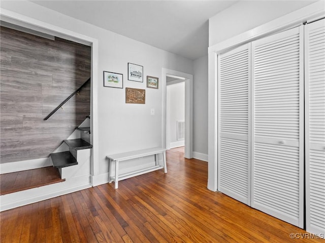 interior space with a closet, visible vents, baseboards, and wood-type flooring