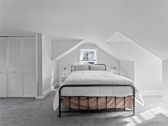 bedroom featuring a closet, baseboards, carpet, and vaulted ceiling