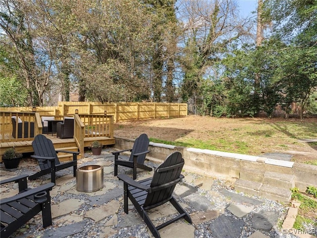 view of patio / terrace featuring a fenced backyard, a fire pit, and a deck