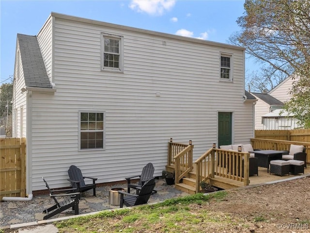 rear view of house featuring a patio area, fence, roof with shingles, and an outdoor hangout area