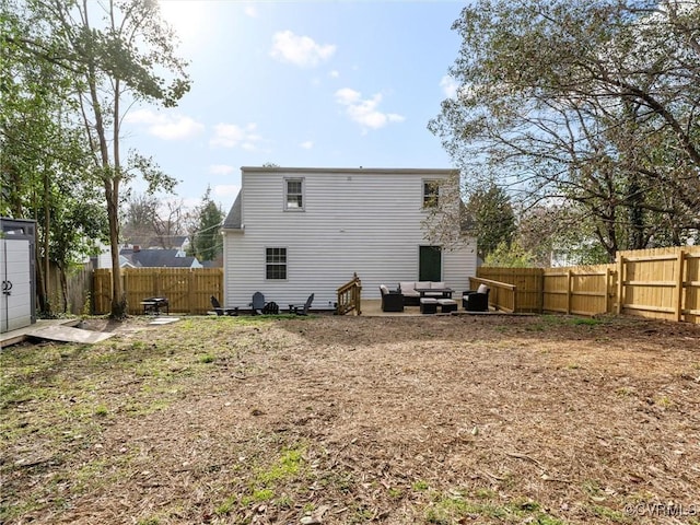 back of property featuring a storage shed, an outdoor structure, a fenced backyard, and an outdoor living space