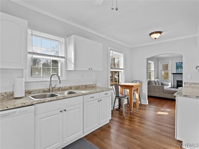 kitchen featuring dark wood-style flooring, ornamental molding, a sink, white cabinets, and dishwasher