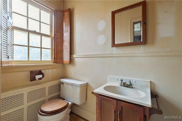 bathroom featuring wallpapered walls, toilet, and vanity