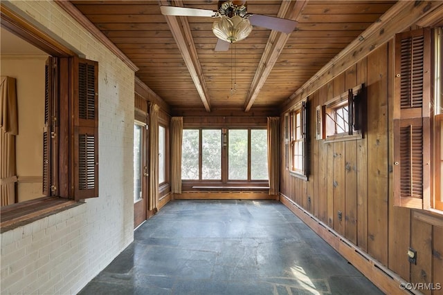 unfurnished sunroom featuring wood ceiling and a ceiling fan