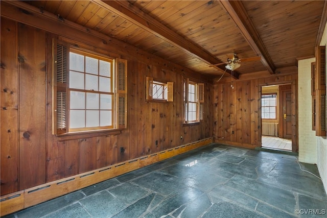 unfurnished room featuring wood walls, radiator heating unit, beam ceiling, wooden ceiling, and stone tile flooring