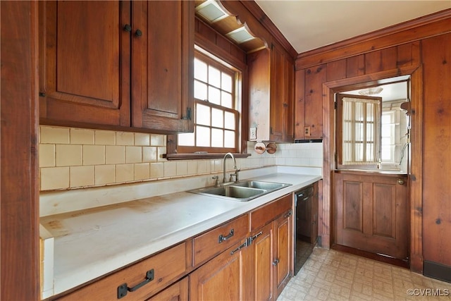 kitchen featuring light floors, a sink, light countertops, dishwasher, and brown cabinets