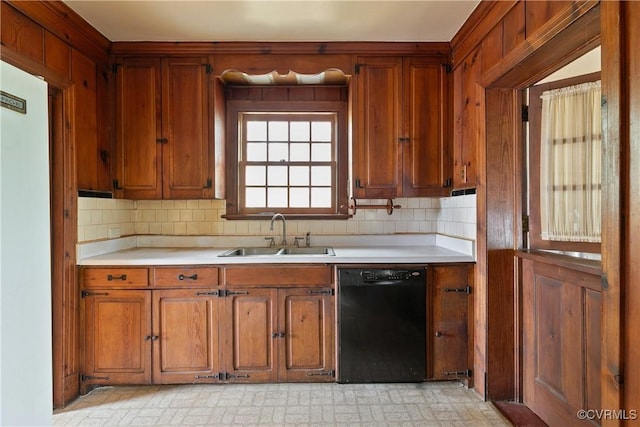 kitchen featuring light countertops, black dishwasher, white fridge, and a sink