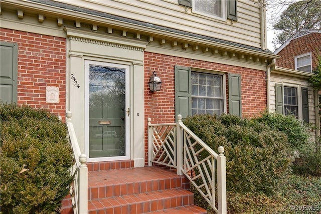 entrance to property featuring brick siding