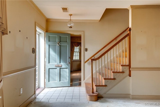 foyer entrance with visible vents, stairs, crown molding, and baseboards