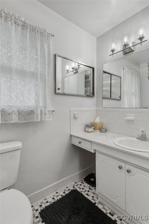 bathroom with baseboards, toilet, decorative backsplash, tile patterned floors, and vanity