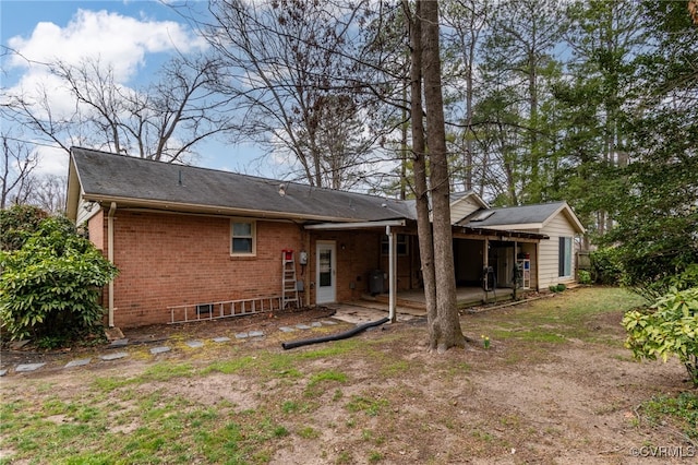 back of property featuring brick siding and a patio area