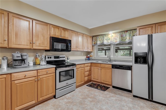 kitchen with a sink, light countertops, light brown cabinetry, and stainless steel appliances