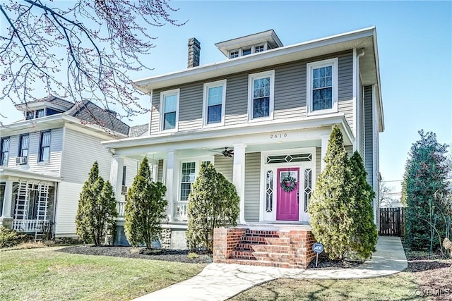 american foursquare style home with covered porch and a chimney