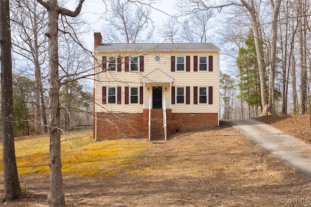 colonial home with crawl space, driveway, and a chimney