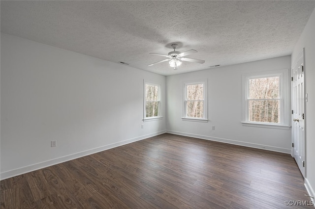 empty room with dark wood finished floors, a textured ceiling, baseboards, and ceiling fan