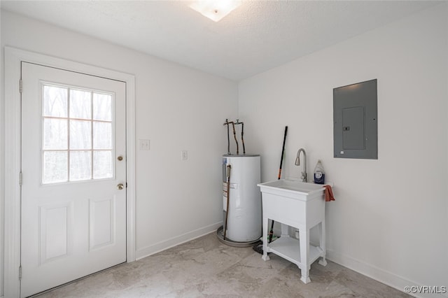 laundry area with baseboards, water heater, laundry area, electric panel, and a textured ceiling