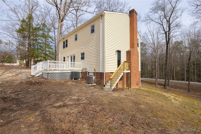 back of property with crawl space, central air condition unit, a chimney, and a deck