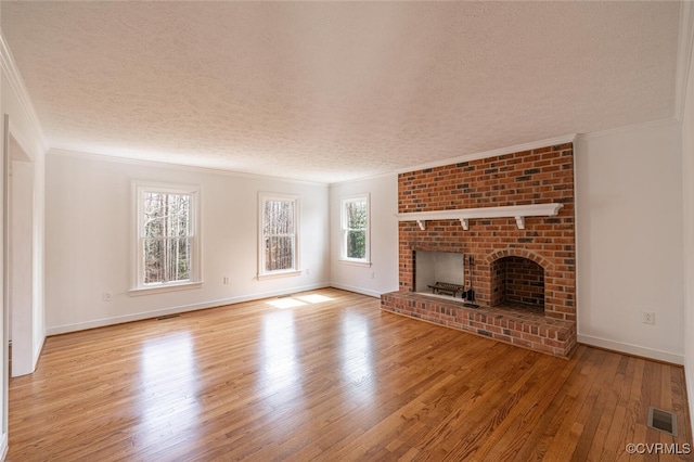 6924 Longview Dr, New Kent, VA 23141 - unfurnished living room featuring a textured ceiling, wood finished floors, ornamental molding, a fireplace, and baseboards