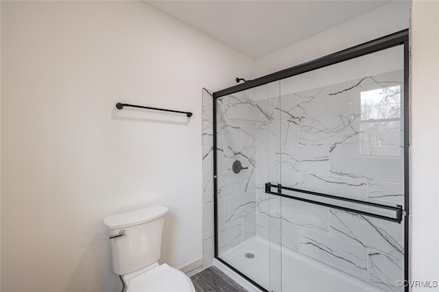 full bath with toilet, baseboards, and a stall shower