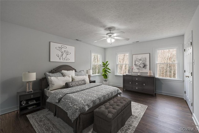 bedroom featuring visible vents, a textured ceiling, dark wood-style floors, baseboards, and ceiling fan