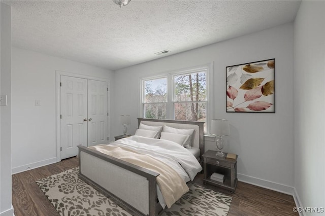 bedroom featuring a closet, baseboards, and wood finished floors