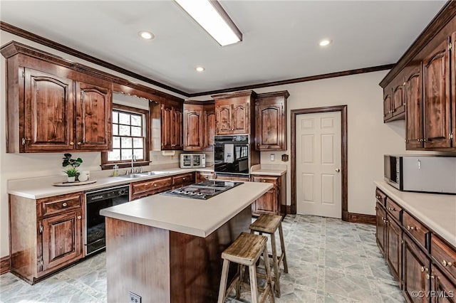 kitchen with a sink, black appliances, light countertops, a kitchen bar, and crown molding