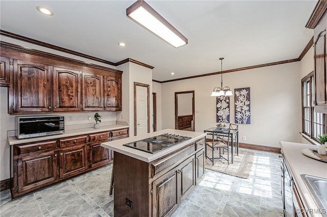 kitchen featuring stovetop with downdraft, dark brown cabinetry, an inviting chandelier, light countertops, and baseboards