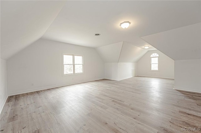 bonus room featuring baseboards, lofted ceiling, and light wood-style floors