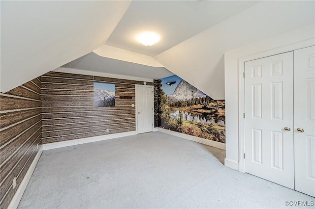 bonus room featuring wooden walls, lofted ceiling, and carpet floors