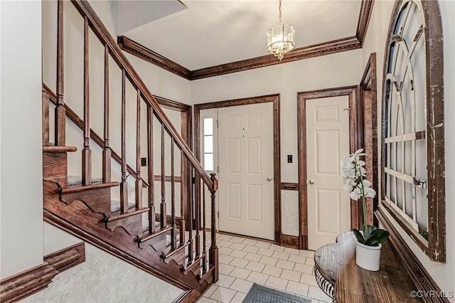 foyer entrance with stairs, an inviting chandelier, light tile patterned flooring, and ornamental molding