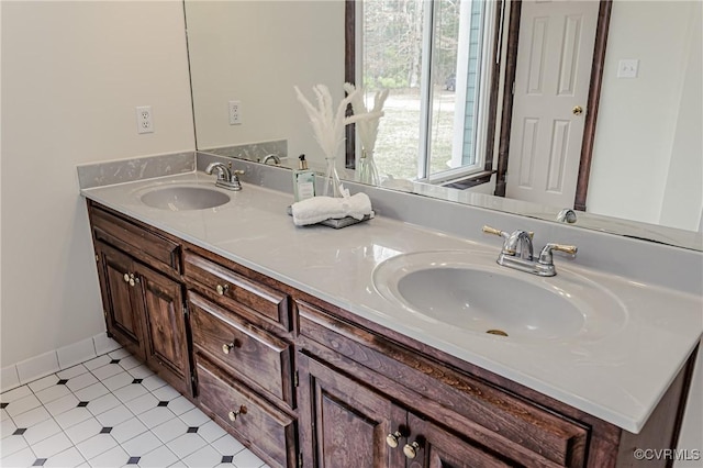 bathroom with a sink, baseboards, and double vanity