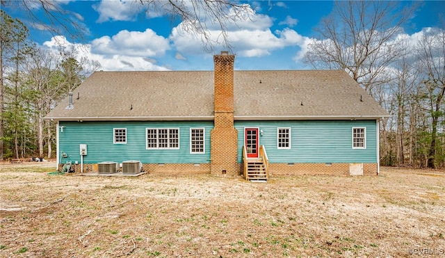 rear view of house with entry steps, cooling unit, a chimney, and crawl space