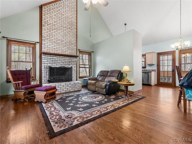 living area with plenty of natural light, a notable chandelier, wood finished floors, and a fireplace