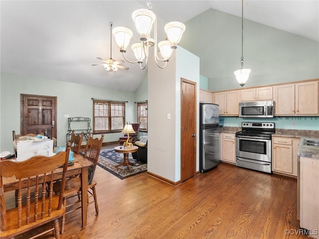 kitchen with light brown cabinetry, appliances with stainless steel finishes, dark wood-type flooring, and decorative light fixtures