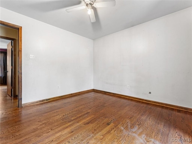 spare room featuring ceiling fan, baseboards, and wood finished floors