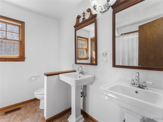 full bath featuring tile patterned flooring, visible vents, baseboards, toilet, and a sink