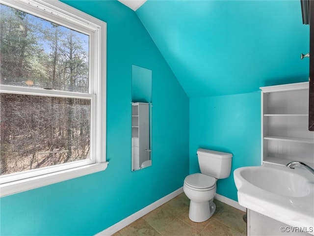 bathroom featuring toilet, lofted ceiling, and baseboards