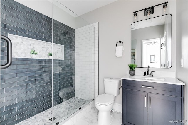 full bath with baseboards, toilet, tiled shower, marble finish floor, and vanity