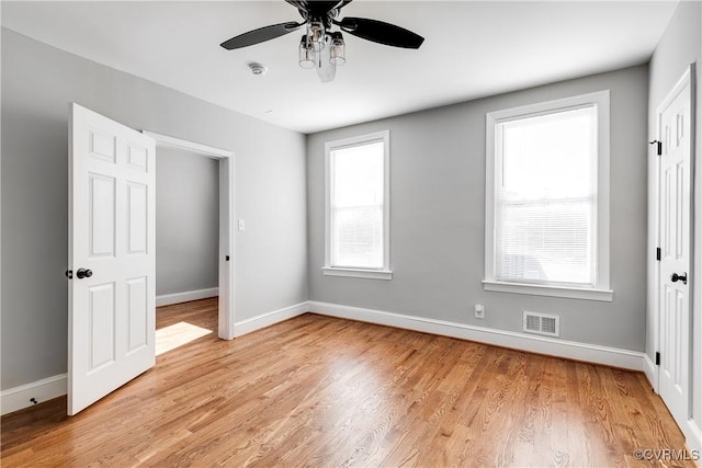 unfurnished bedroom with visible vents, ceiling fan, baseboards, and light wood-style floors