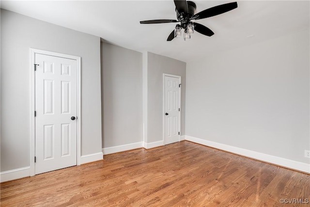 unfurnished bedroom featuring light wood-style flooring, a ceiling fan, and baseboards