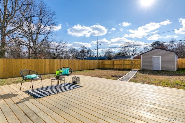 wooden deck featuring a storage unit, an outdoor structure, and a fenced backyard