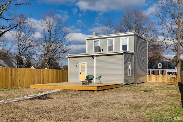 back of house with a yard, a fenced backyard, a chimney, and a wooden deck